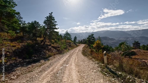 Off-road driving in 4WD vehicles on dirt roads among mountains and hills at high speed. First-person perspective. Shot with an action camera without motion blur in autumn.