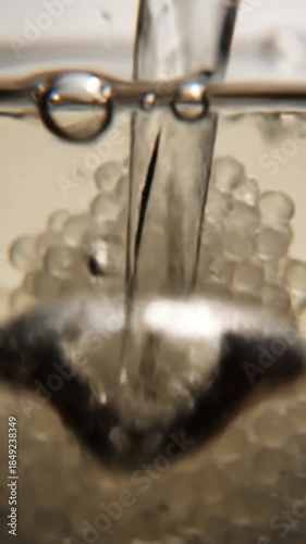 Close up of water pouring with bubbles creating texture and movement abstract background