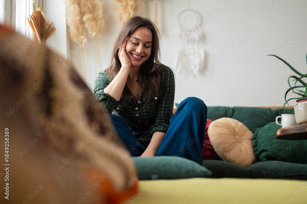 Naklejka premium Young woman relaxing and smiling casually on couch at home