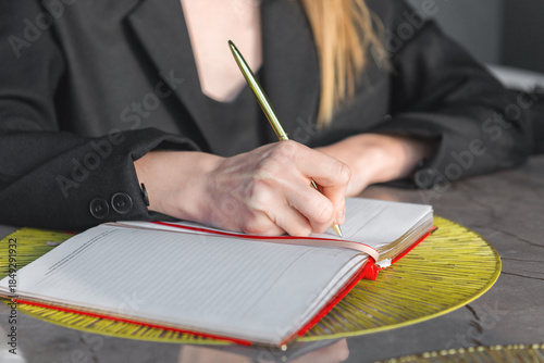 Close-up of a hands holding a pen and a notebook.