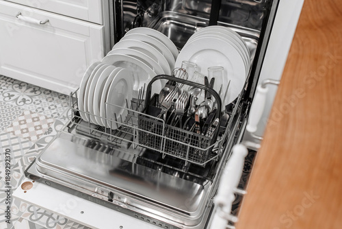 Quadro em tela Modern dishwasher loaded with clean plates, glasses, and cutlery, showcasing org