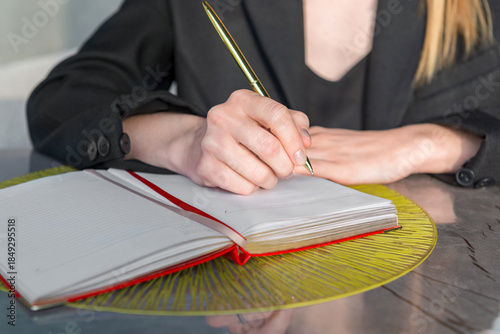 Close-up of a hands holding a pen and a notebook.