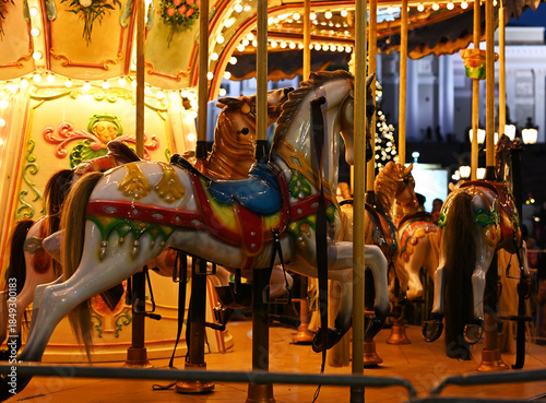 A warmly lit carousel turns quietly at night
