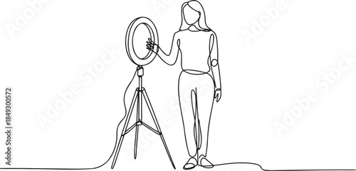 Continuous line drawing of a woman standing next to a ring light on a tripod