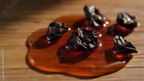 Close-up of Myrrh Resin in Amber Liquid on Wood Surface