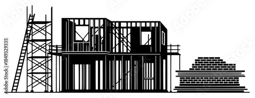 Residential house construction site with wooden framing scaffolding and brick stack