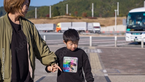 Photography Parent supporting a child with severe developmental disability while walking nea