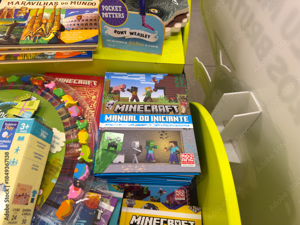 Fototapeta premium BELO HORIZONTE, MG, BRAZIL, DECEMBER 12, 2025 Popular children's books and playful toys fill a bright retail display, inviting young readers and gamers.