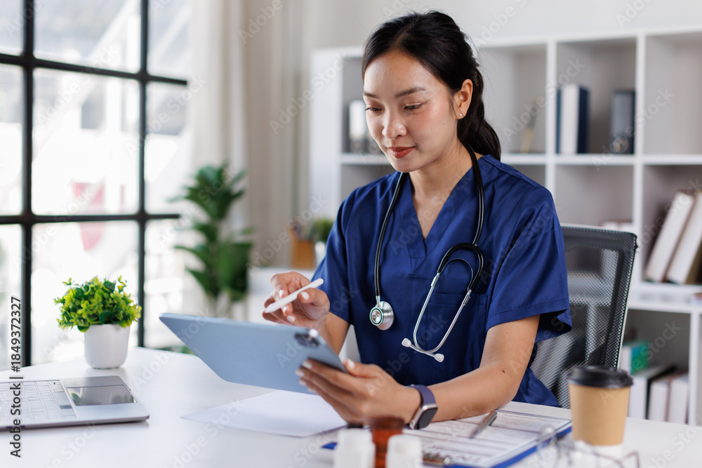© David - An attractive and professional Asian female doctor with blue coat or Asian female doctor working on her medical cases at her desk in the office at a hospital.