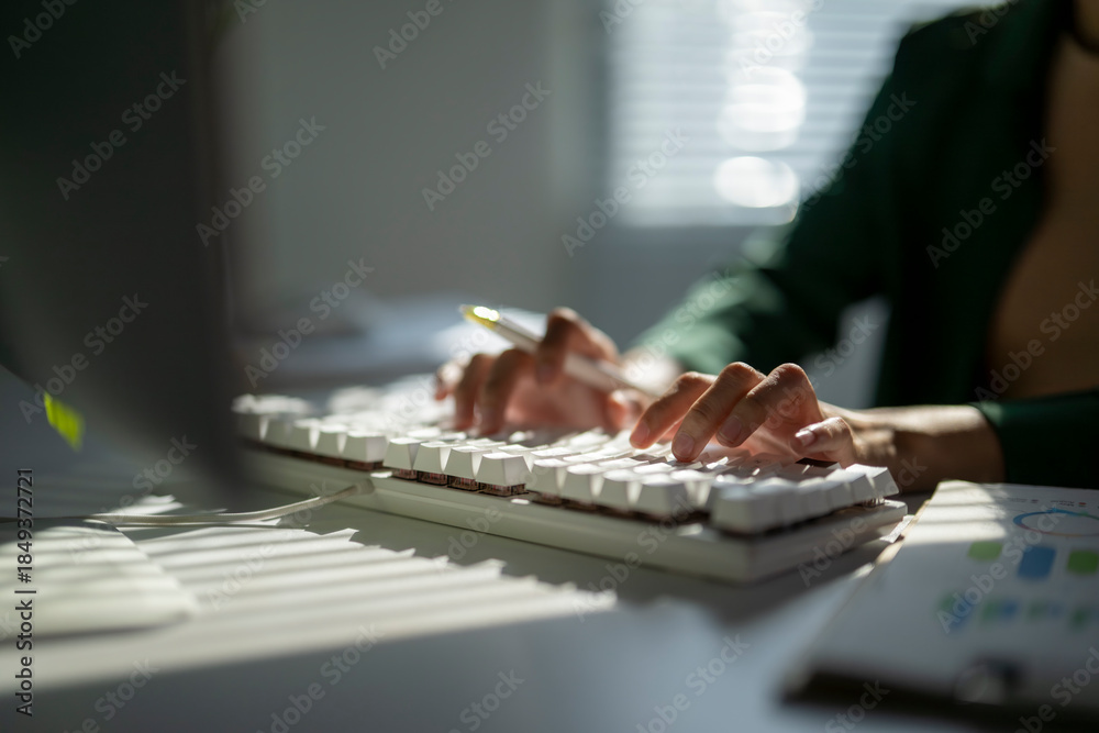 Fototapeta premium Person typing data on computer keyboard at desk