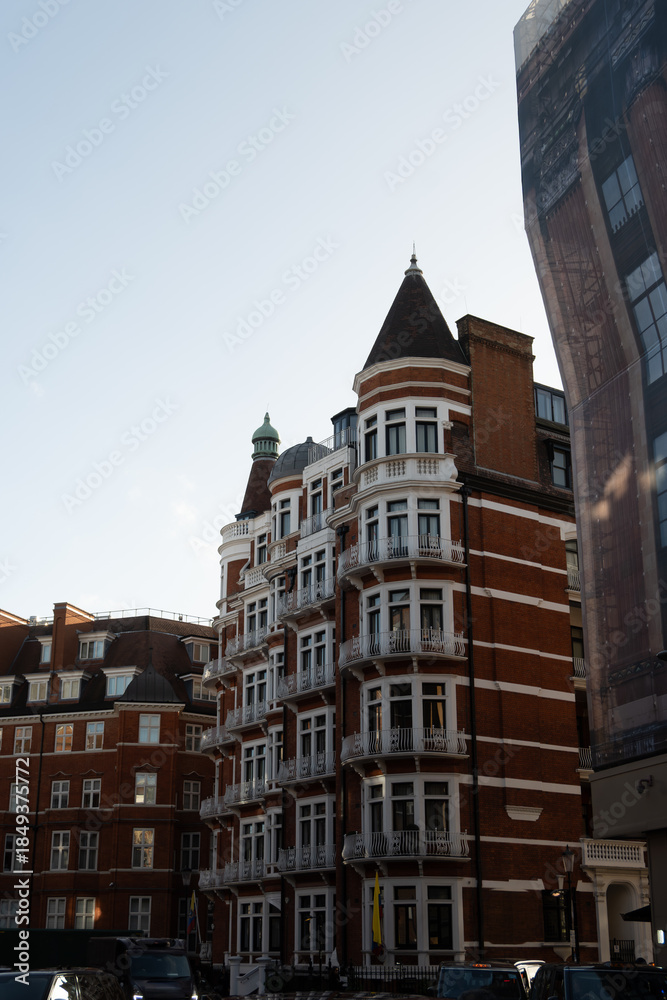 Fototapeta premium Stroll along Hans Crescent with elegant red brick townhouses and vibrant city life Knightsbrigde in London