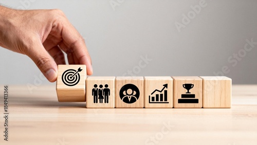Hand arranging wooden blocks with icons