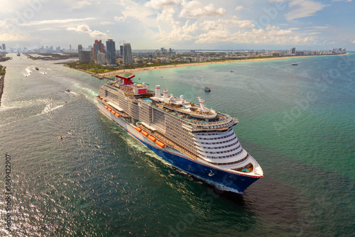 Fotografi Large passenger cruise ship departing Miami port at sunset