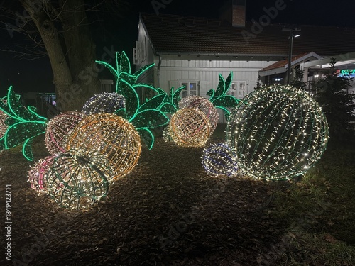 Warsaw, Poland - December 18, 2025: Colorful illuminated fruit decorations with vibrant lights in a festive outdoor display, creating a magical atmosphere during the holiday season