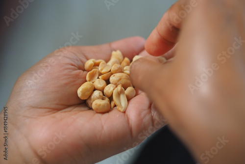 Hand holds peanuts for a snack in casual setting