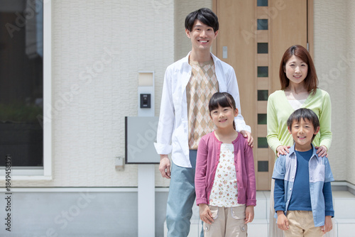 自宅の玄関先に立つ家族