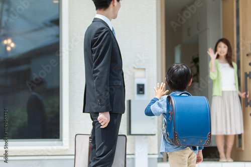 玄関先で見送る母親と家族