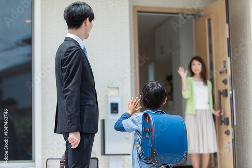 玄関先で見送る母親と家族