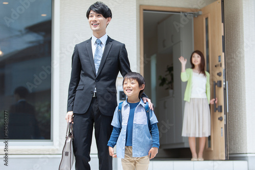 玄関先で見送る母親と家族