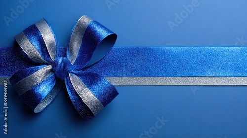 A shimmering blue and silver ribbon bow on a blue background, perfect for wrapping gifts or decorations.