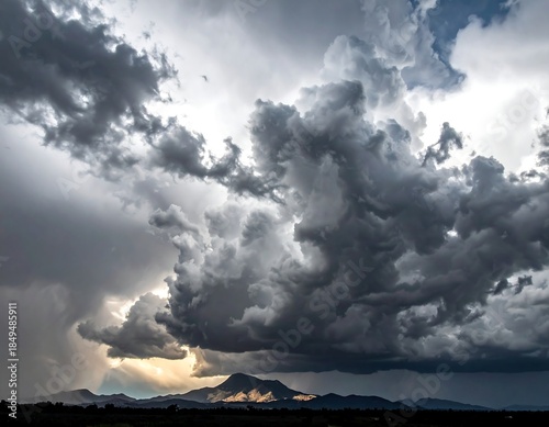 Dramatic cloudscape with light rays over mountain silhouettes