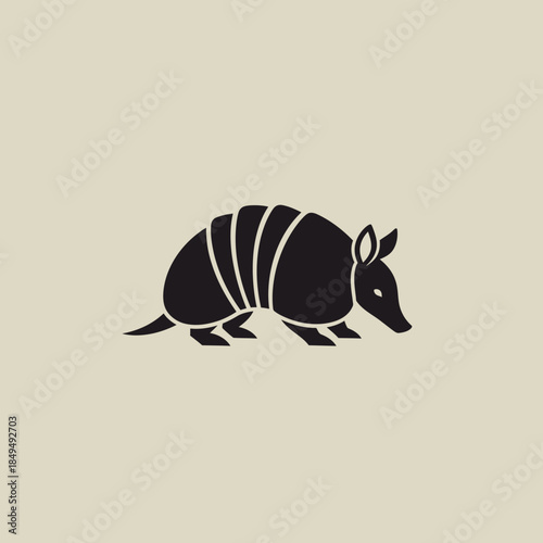 A minimalist black silhouette of an armadillo on a light beige background, representing wildlife