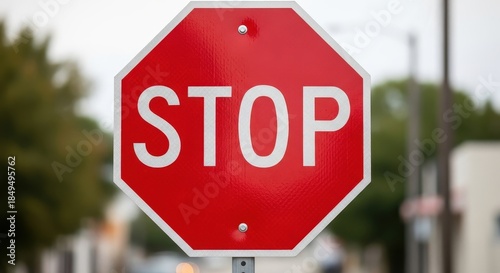 Stop sign in outdoor setting with bold red color and white lettering on metal texture for traffic signage