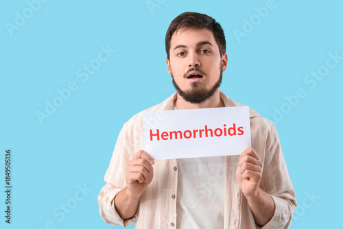 Young man holding paper wit...