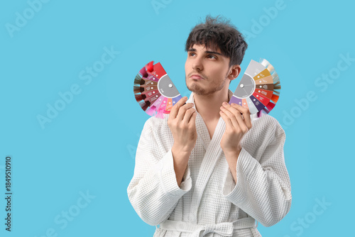 Sad young man in bathrobe w...