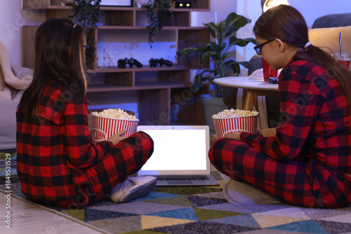 Cute sisters with popcorn w...