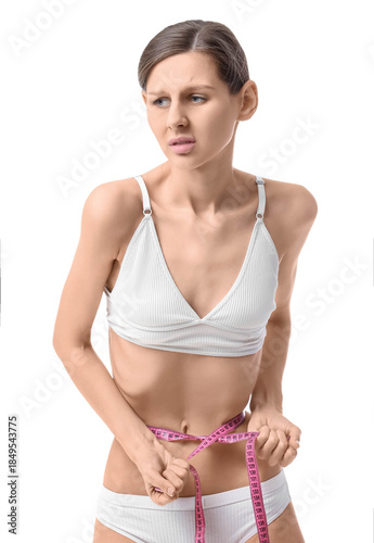 Schilderij op canvas Young woman with anorexia measuring waist on white background