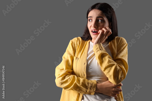 Scared young woman on dark ...