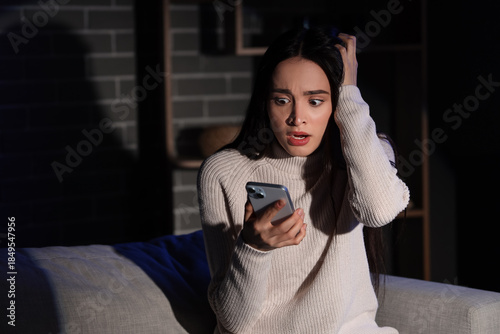 Scared young woman using mo...