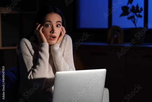 Scared young woman using la...