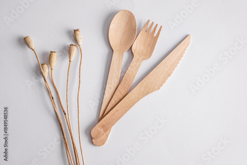 Eco friendly wooden cutlery with dry grass on white background