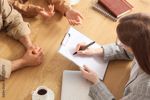 Tableau sur toile Female family mediator working with couple at table in office, top view