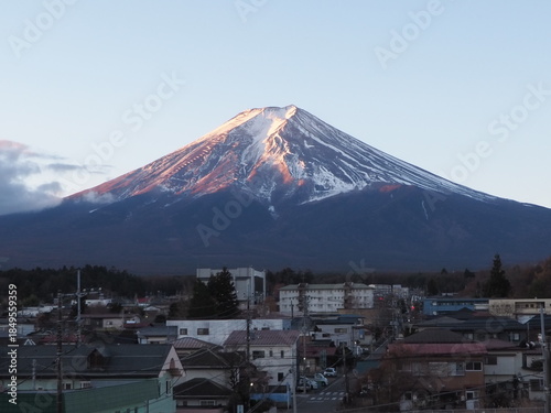 A view of Mount Fuji at sunset, with a village in the foreground.