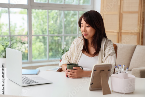 Young Asian woman with cup ...