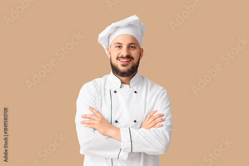 Male chef smiling on beige ...