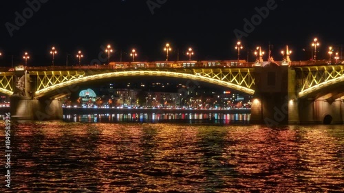 Panoramic view of Budapest city and Danube River at night, bridges, tour boats, urban architecture with beautiful illumination, street lights and road traffic
