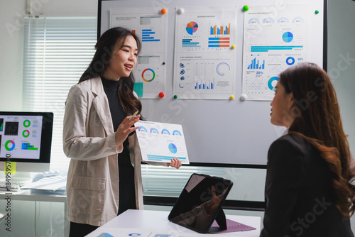 Businesswoman presenting data reports during office team meeting