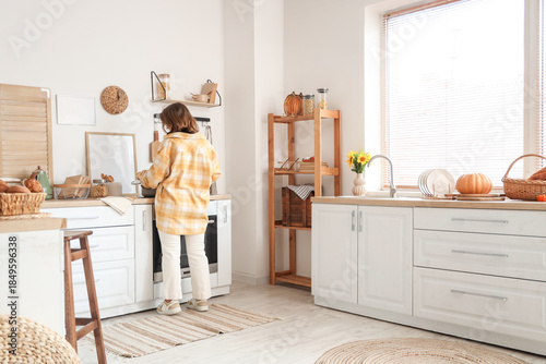 Young woman cooking in kitc...