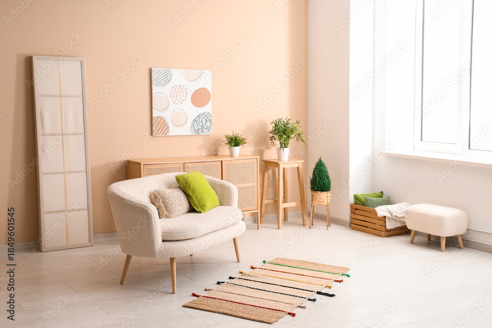 Fototapeta premium Interior of light living room with sofa near beige wall