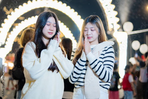  A young woman wearing a scarf and gloves is smiling outdoors in the snow during the winter.