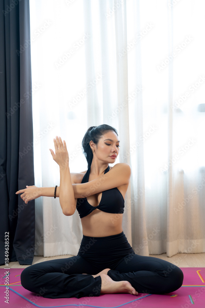 Fototapeta premium Woman yoga stretch indoor lifestyle calm fitness wellness activewear black outfit serene morning light curtain background home exercise mat