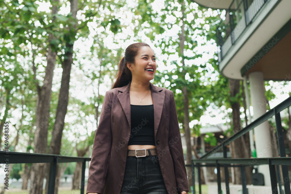 Obraz premium Young asian woman smiling, feeling happy outdoors