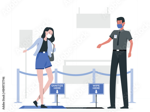 Woman and man wearing face masks standing near sanitation and wipe down signs sanitize