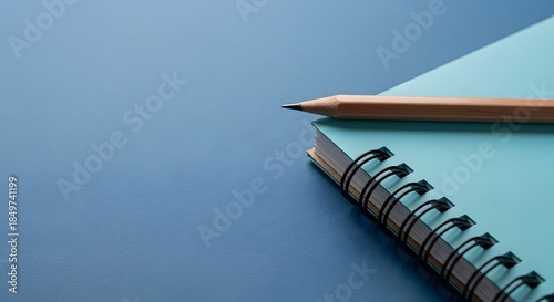 Light Blue Spiral Notebook with Wooden Pencil on Blue Surface notepad writing
