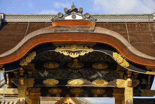 Kyoto. Ancient Japanese Temple Gate With Ornate Wooden Archway And Traditional Tiled Roof In Sunlight Today