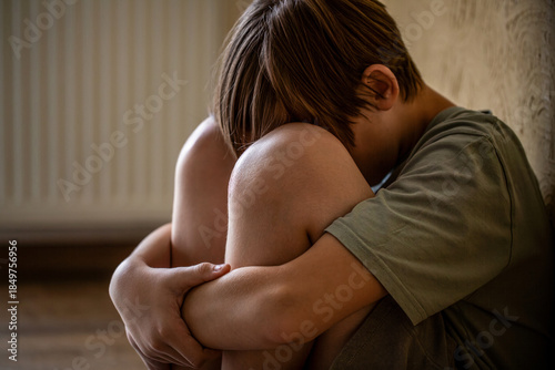 Foto Sad child suffering from depression sitting alone in home loneliness